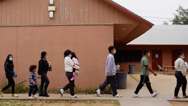 People walking in a line outside a building