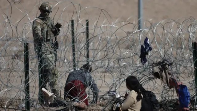 National Guard Texan and migrants on the Mexico-United States border in Ciudad Juarez, Mexico on February 16, 2024 (