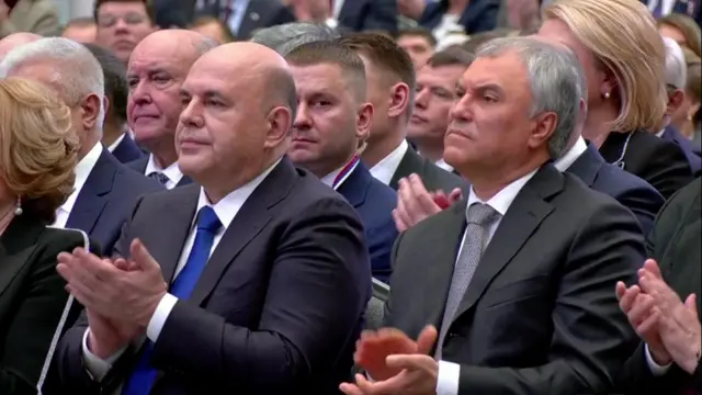 Attendees applaud Putin