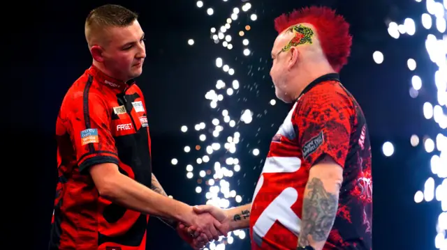 Nathan Aspinall shakes hands with Peter Wright