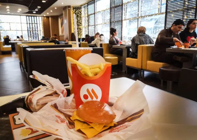 A burger and chips inside a Vkusno i Tochka restaurant