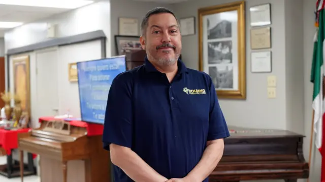 Michael Smith stands in a room in front of two pianos