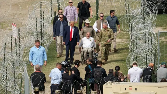 Republican presidential candidate and former U.S. President Donald Trump walks next to Governor Greg Abbott as Trump visits the U.S.-Mexico border at Eagle Pass, Texas, U.S., February 29, 2024