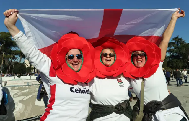 England fans cheering in the sunshine, with rose head dresses on