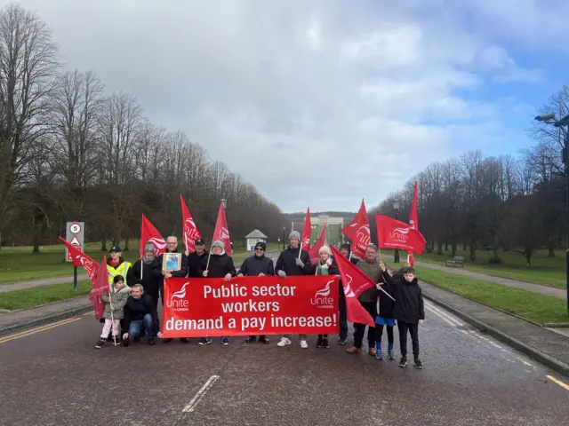 Group of people carrying unite flags and banners at Stormont