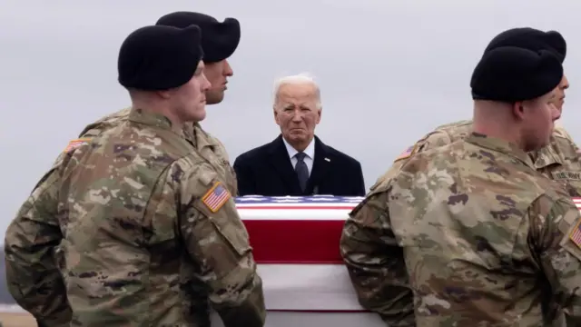 US President Joe Biden (C) watches as a US Army carry team moves a flag-draped transfer case containing the remains of US Army Sergeant Jerome Rivers, during a dignified transfer of fallen US service members, at Dover Air Force Base in Dover, Delaware