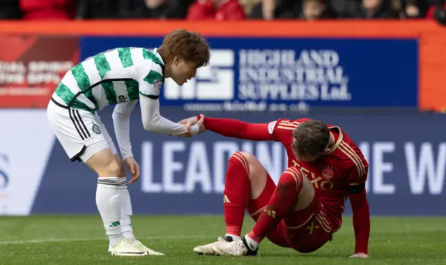 Celtic's Kyogo Furuhashi helps Aberdeen's Nicky Devlin up