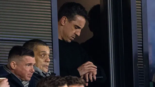 Gary Neville looks at his watch