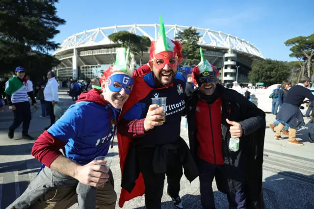 Italian fans with superhero masks on, outside the stadium