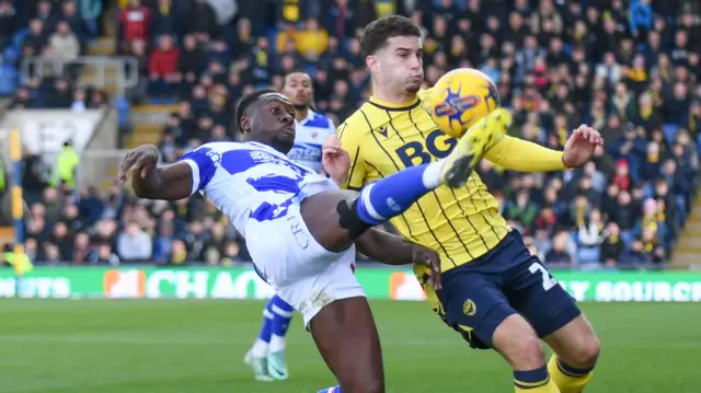 Oxford and Reading players challenge for the ball