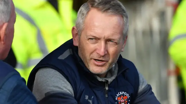 Blackpool manager Neil Critchley sits in the dugout