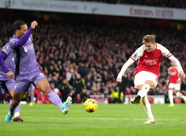 Martin Odegaard takes a shot as Virgil van Dijk