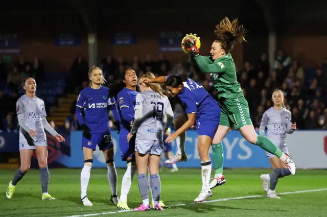 Courtney Brosnan claims a cross in the air under pressure from Jess Carter.