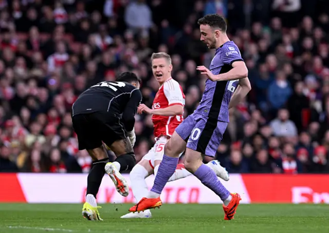 Diogo Jota is beaten to the ball by David Raya