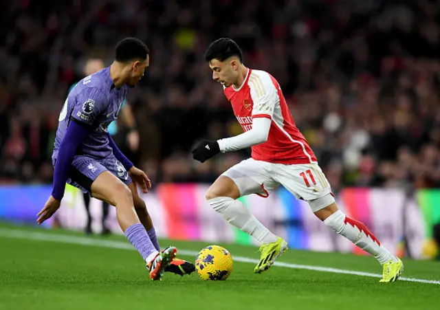 Gabriel Martinelli of Arsenal runs with the ball whilst under pressure from Trent Alexander-Arnold