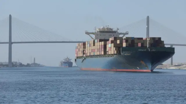 A container ship is seen near Suez Canal Bridge