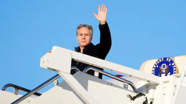 US Secretary of State Antony Blinken waves as he boards a plane en route to the Middle East