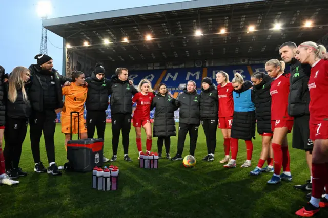 Matt Beard speaks to the Liverpool squad on the pitch at full time.