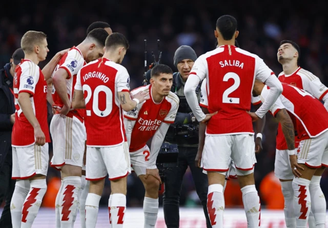 Arsenal players huddle before kick off