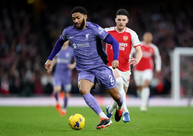 Joe Gomez of Liverpool runs with the ball whilst under pressure from Declan Rice