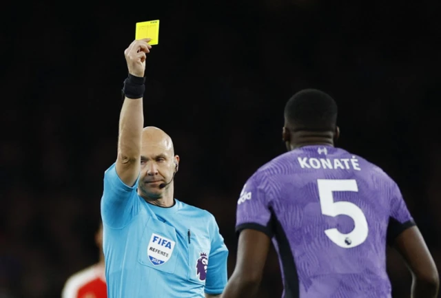 Anthony Taylor shows Konate a yellow card