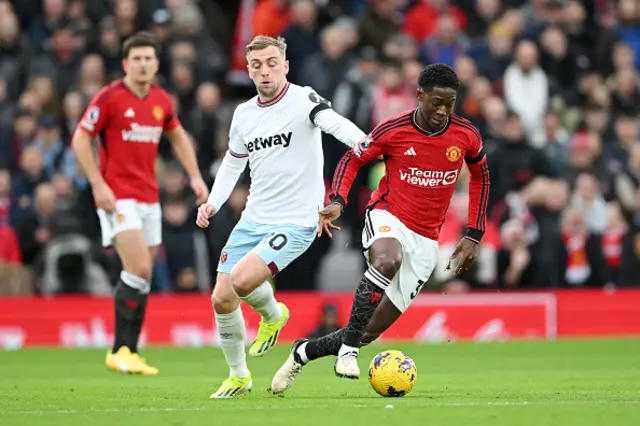 Kobbie Mainoo of Manchester United on the ball whilst under pressure from Jarrod Bowen