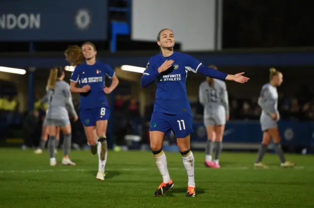 Reiten celebrates her second goal of the game by tapping the badge on her chest,