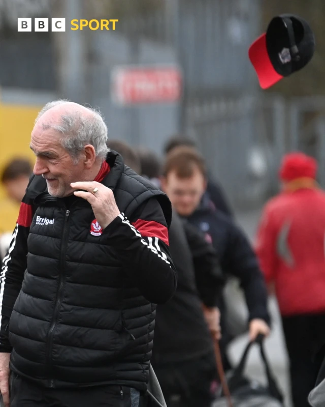 Derry manager Mickey Harte's hat blows away in the wind