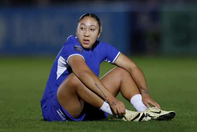 Lauren James sits on the floor and gestures for medical treatment.