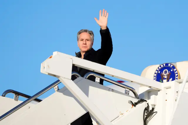 Antony Blinken waves just before he enters an aircraft en route to Saudi Arabia