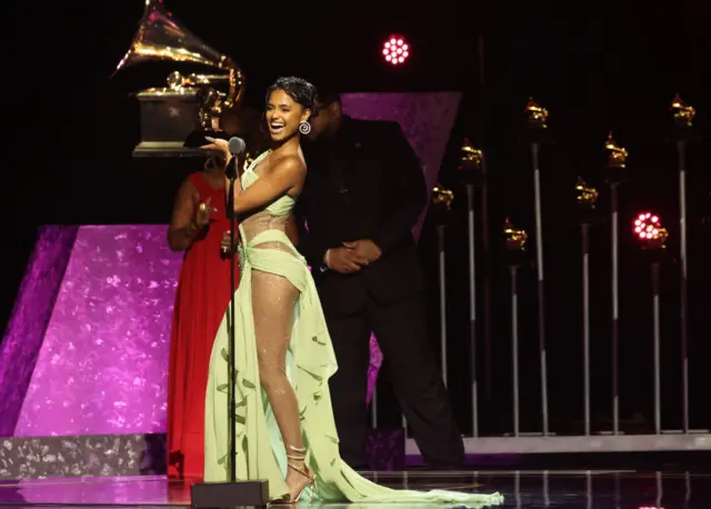 Tyla holding her Grammy.