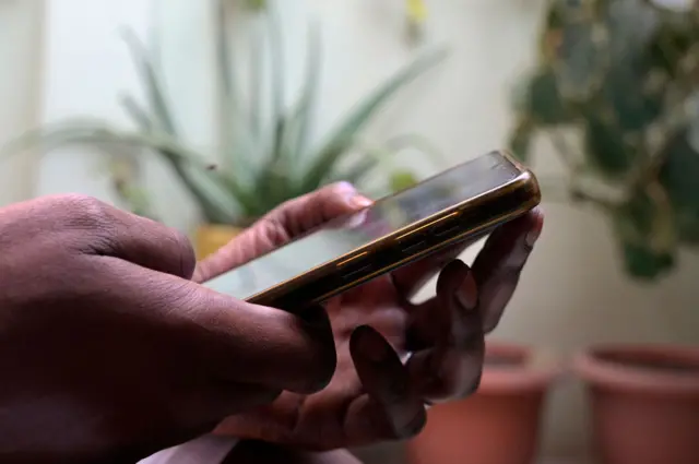 A person holds a mobile phone in Dakar on August 9, 2023.