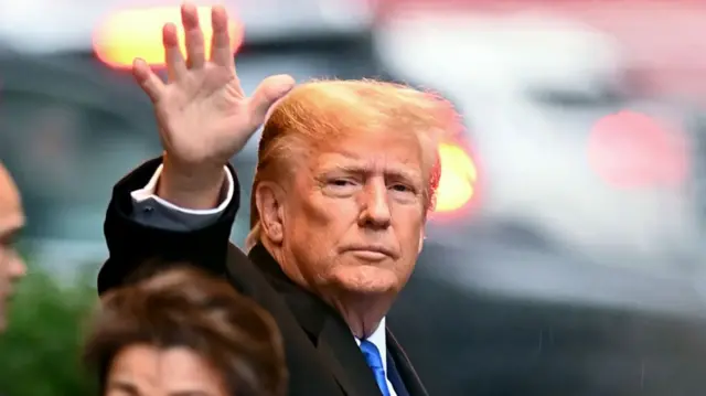 Donald Trump waves at a camera