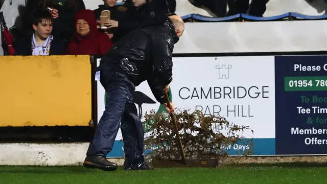 Water being swept off football pitch at Cambridge