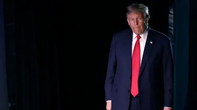 Donald Trump in front of a black curtain