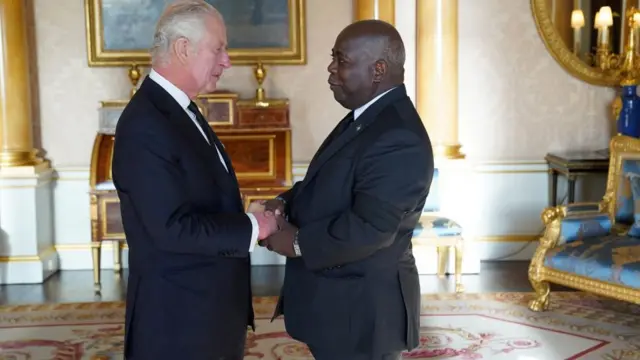 King Charles stands on the left and shakes hands with Prime Minister of the Bahamas, Philip Davis