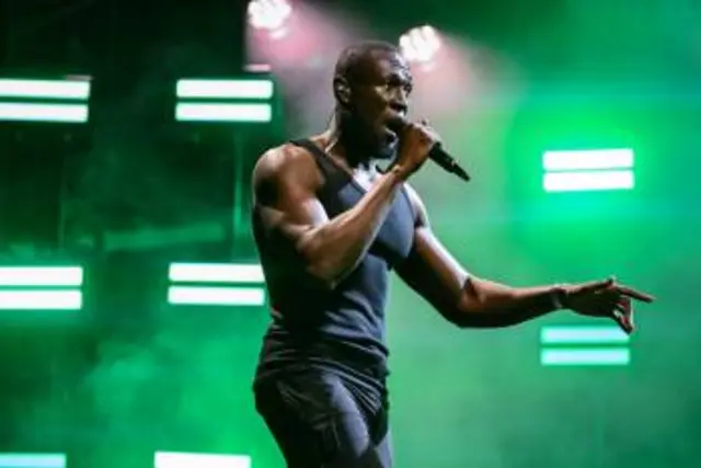 Stormzy performing, wearing a black vest