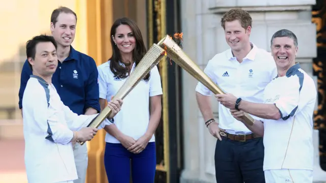 William, Catherine and Harry stand with two London 2012 Olympic Torch bearers.