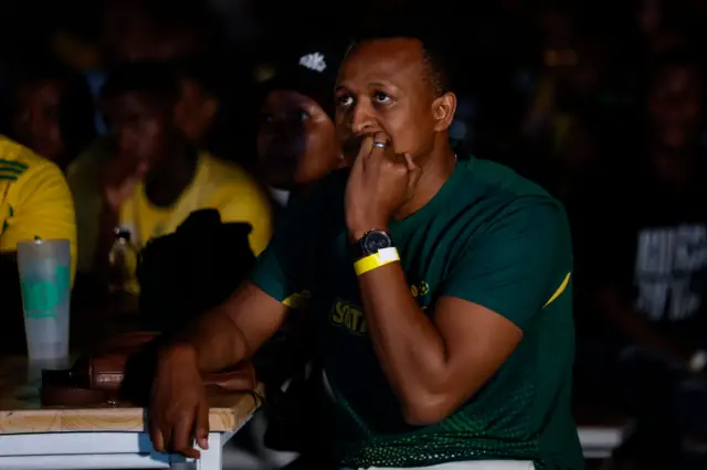 A fan bites his nails as he watches on nervously.