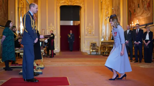 Ellen Convery curtsies before the Prince of Wales at the investiture ceremony