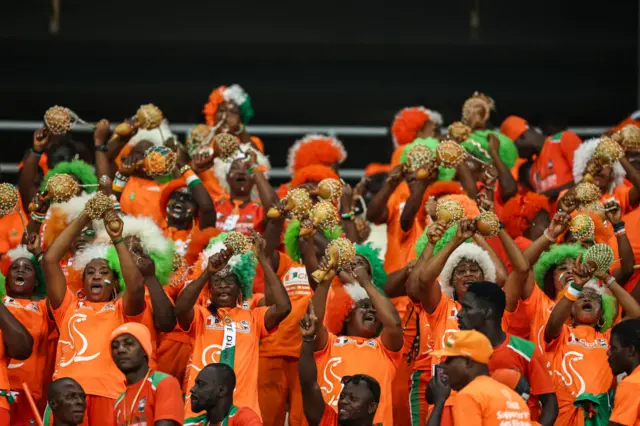 Ivory Coast fans chant and sing in the stands.