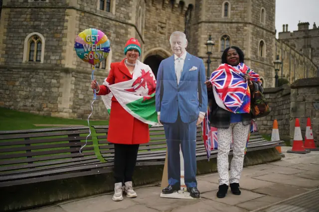 Well-wishers are waiting outside Windsor Castle with a carboard cut-out of King Charles III