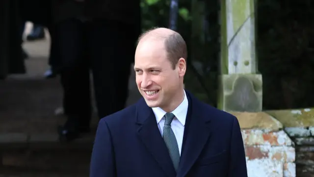 Prince William smiles and looks to the left