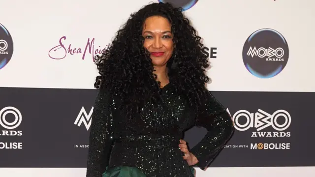Mobo founder Kanya King has her hand on her hip on the red carpet for the Mobo Awards