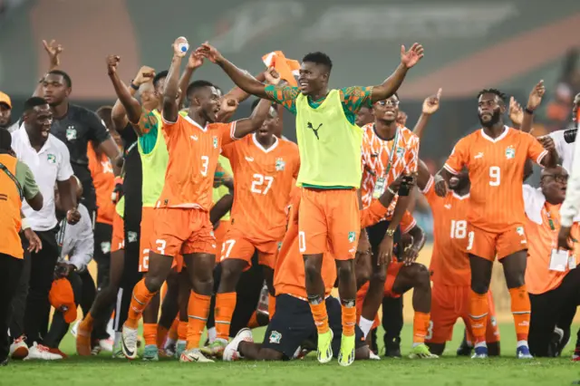 Ivory Coast players celebrate on the pitch at full time.