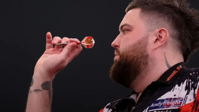 Michael Smith throws a dart