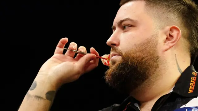 Michael Smith throws a dart