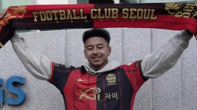 Jesse Lingard holds up an FC Seoul scarf