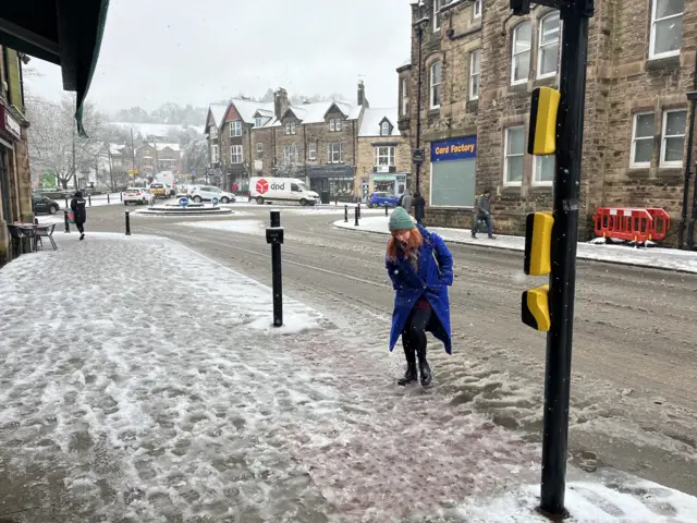 A woman crossing a snowy road