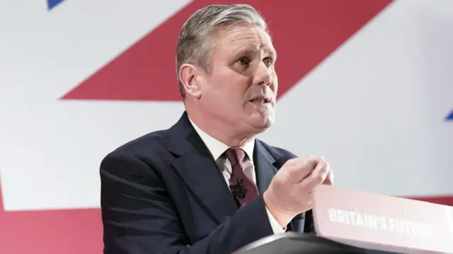 Labour leader Sir Keir Starmer gestures as he speaks at a lectern, which reads: "Britain's future"